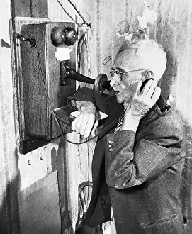 Man Talks on Old-Style Telephone