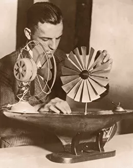 Man testing model of windmill ship propeller (B&W sepia tone)