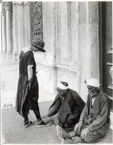 Muslim Prints: Man Ties Slippers on Tourist at Mosque