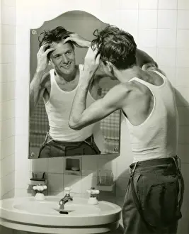 Man in undershirt massaging scalp