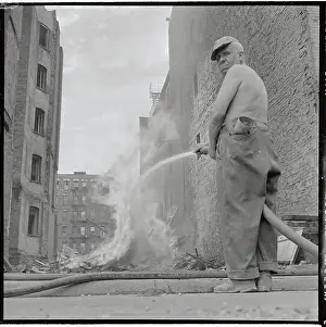 Man Using Hose to Contain Fire