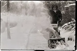 Man Using Snowblower to Clear Sidewalk