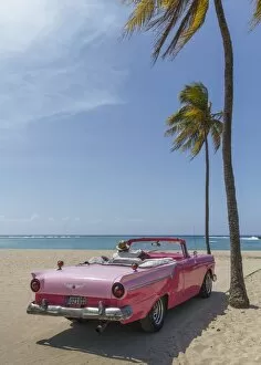 Looking At View Gallery: Man on a vintage car on the beach