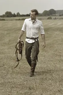 Riders Prints: Man wearing riding clothes walking in a field in summer