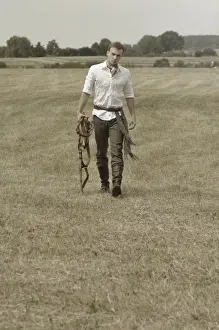 Riders Prints: Man wearing riding clothes walking in a field in summer