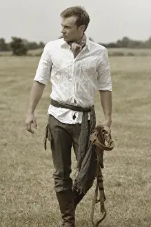 Riders Prints: Man wearing riding clothes walking in a field in summer