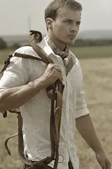 Riders Prints: Man wearing riding clothes walking in a field in summer holding a leather strap