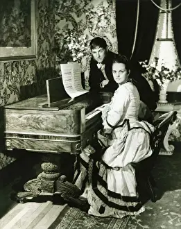 Bending Down Prints: Man and woman posing at spinet, (B&W), portrait
