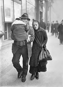 Hard Prints: Man and Woman Traveling by Foot with Child