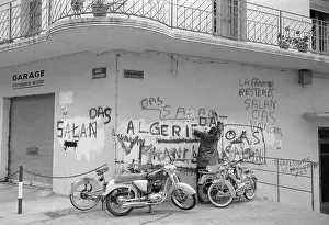 Man Writes French OAS Grafitti on Wall