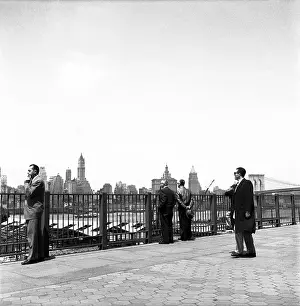 Prints of BROOKLYN, NY - MARCH 1958: People admire the Manhattan skyline and the Brooklyn Bridge from the Brooklyn Promenade in Brooklyn Heights, in March, 1958 in New York City, New York Portraits, Artworks, and Montages from a Visionary Photographer: Manhattan Skyline From the Brooklyn Promenade in the 1950's