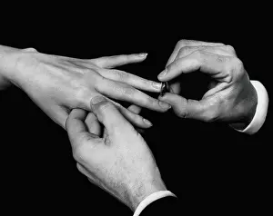 Man's hand putting ring on woman's finger