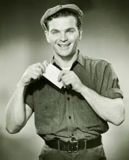 Manual Prints: Manual worker holding pay envelope, (B&W), portrait