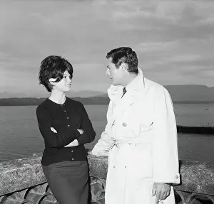 Prints of (Original Caption) 9/16/1961-Italian film star Marcello Mastroiani is shown with French actress Brigitte Bardot, leaning on a structure overlooking a body of water. 3/4 length photograph Captivating Moments: Brigitte Bardot in Action: Marcello Mastroianni and Brigitte Bardot