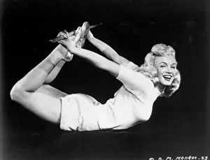 Prints of CIRCA 1950: Actress Marilyn Monroe poses for a film publicity shot holding her legs behind her back with a stick while laying on her stomach in circa 1950 Marilyn Monroe: The Eternal Star Prints: Marilyn Doing Yoga