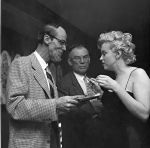 Prints of LOS ANGELES - MARCH 3: Movie star Marilyn Monroe chats with photographer Earl Leaf during a press party held at her home on March 3, 1956 in Los Angeles, California Marilyn Monroe: The Iconic Muse Prints: Marilyn & Earl