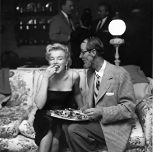 Prints of LOS ANGELES - MARCH 3: Movie star Marilyn Monroe chats with photographer Earl Leaf during a press party held at her home on March 3, 1956 in Los Angeles, California Marilyn Monroe: The Iconic Muse Prints: Marilyn & Earl
