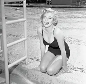 Prints of 7/1/1952-ORIGINAL CAPTION READS: Marilyn Monroe in swimsuit by pool side Marilyn Monroe: A Fashion Legacy: Marilyn Monroe Sitting by Pool in Swimsuit