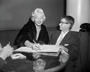 Marilyn Monroe Sitting with Young Boy Wearing Eyeglasses