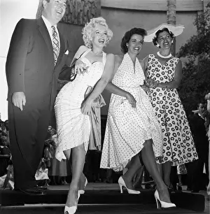 Prints of EXCLUSIVE American actresses Marilyn Monroe (1926 - 1962) (left) and Jane Russell, bookended by an unidentified man and woman Hollywood's Sultry Siren – A Photographic Tribute: Marilyn And Russell