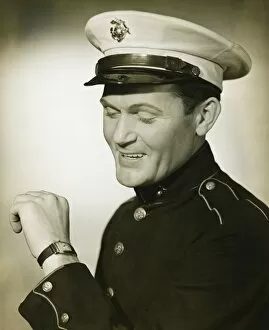 35 39 Years Collection: Marine in military uniform looking at wristwatch in studio, (B&W)
