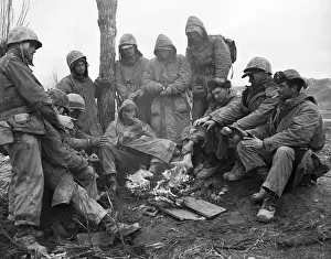 Marines Warm Themselves By Fire