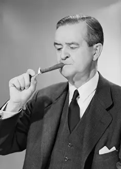 Mature man lighting cigar