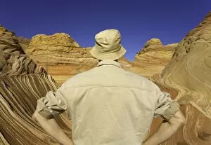 Mature man looking at sandstone buttes, rear view