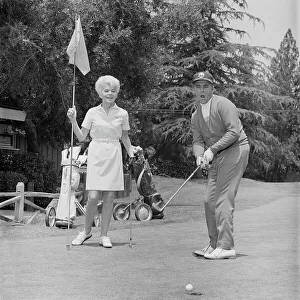 Casual Collection: Mature man putting ball into hole