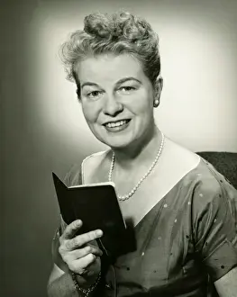 50 59 Years Prints: Mature woman holding small book, posing in studio, (B&W), portrait