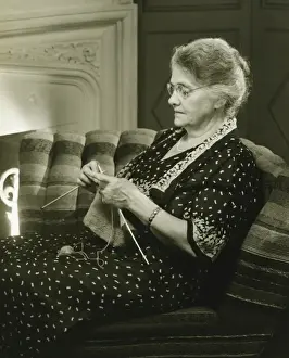 50 59 Years Prints: Mature woman knitting in living room, (B&W)