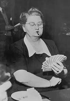 Mature woman playing cards, smoking cigar (B&W)