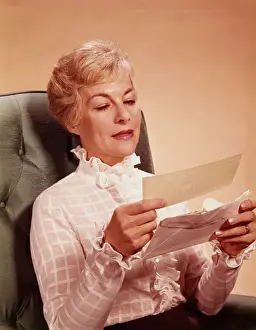 Chair Prints: Mature woman sitting in chair, reading letter