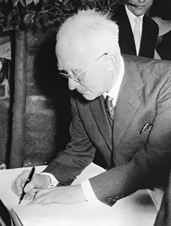 Max Born Seated Writing In Book