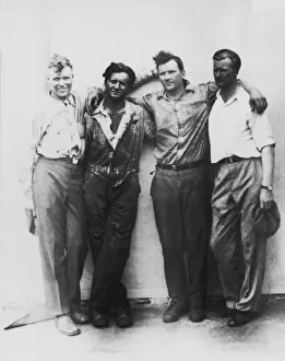 Four men with arms on each others shoulders, portrait (B&W)