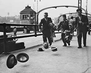 Men Attempting to Capture Windblown Hats