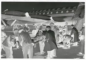 Men Carrying Wounded Diplomats Towards Aircraft