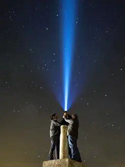 Lost Prints: Men with his close hands illuminating the night sky with a bundle of light