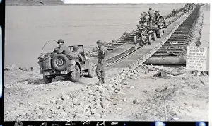 Men, Guns, Vehicles Crossing A Bridge