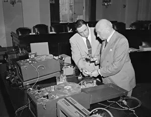 Men Inspecting Electronics Equipment for Bugging Trial
