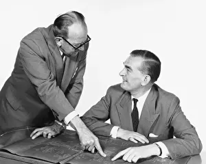 Businessman Prints: Two men, one pointing to blueprint