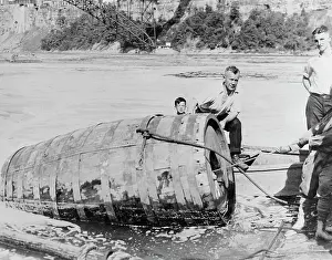 Men Pulling Large Death Barrel from Water