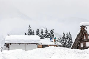 Images Dated 22nd March 2015: Men remove snow from roof during a winter storm