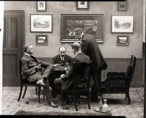 Men Seated At Table Playing Cards