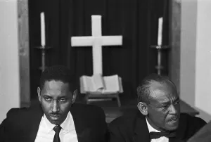Orangeburg Prints: Two Men Sitting in Front of Cross