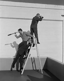 Images Dated 16th August 2011: Men standing on ladder with binoculars and telescope