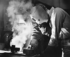 Bib Overalls Gallery: Two men welding, holding protective masks, (B&W)