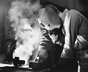 Bib Overalls Gallery: Two men welding, holding protective masks, (B&W)