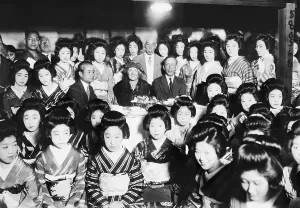 Geisha Prints: Men And Woman Seated, Surrounded By Geish