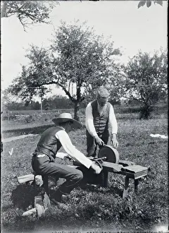 Two Men Working with Early Grindstone